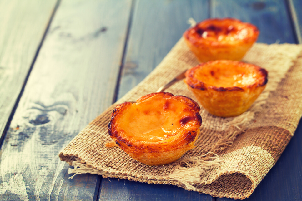 portuguese egg tart pastel de nata on blue wooden background